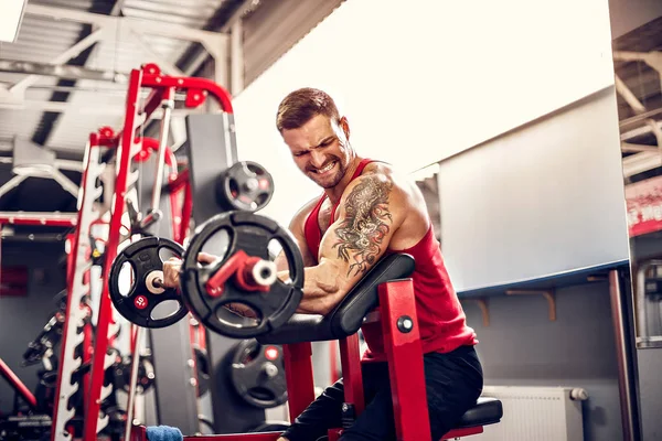 Adam vücut geliştirmeci bir spor salonunda bir halter egzersiz kümesi yapıyor. Gerçek zamanlı vurdu — Stok fotoğraf