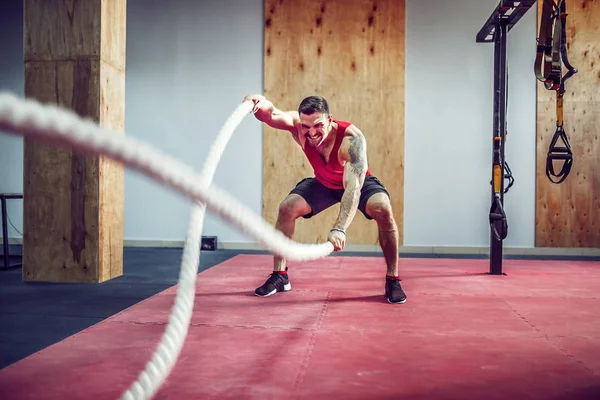 Men with battle rope in functional training fitness