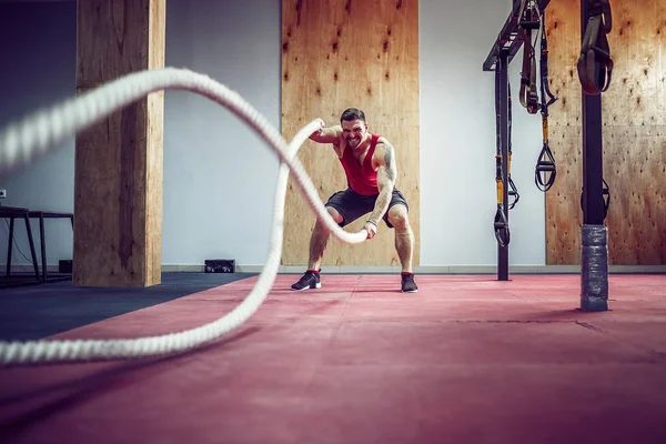 Men with battle rope in functional training fitness