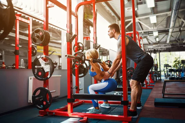 Sportif kız Yardımı salonunda kişisel onu antrenman ör ile bodur egzersizleri yapıyor.