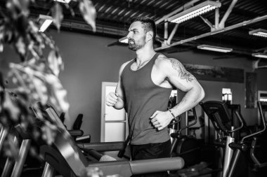 Kas koşu bandı üzerinde çalışan adam.