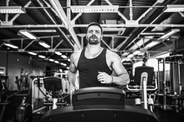 Kas koşu bandı üzerinde çalışan adam.