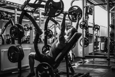 Simülatörde omuzlar için bir egzersiz yapan erkek