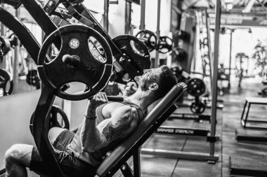 Simülatörde omuzlar için bir egzersiz yapan erkek