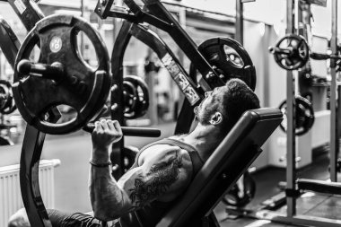 Simülatörde omuzlar için bir egzersiz yapan erkek