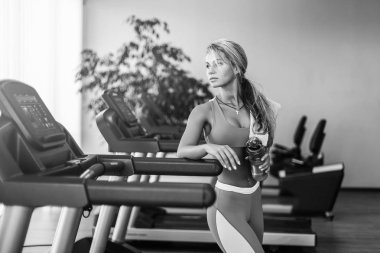 Güzel atletik sarışın kadın içme suyu spor salonunda bir koşu bandı üzerinde olduğunu.
