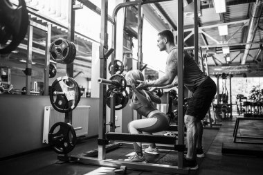 Sportif kız Yardımı salonunda kişisel onu antrenman ör ile bodur egzersizleri yapıyor.