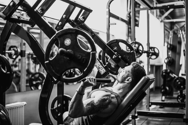 Simülatörde omuzlar için bir egzersiz yapan erkek