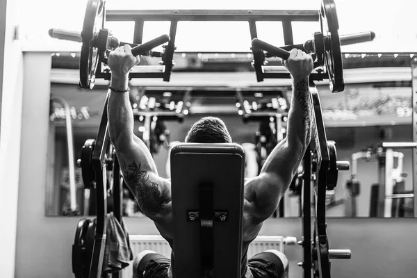 Simülatörde omuzlar için bir egzersiz yapan erkek