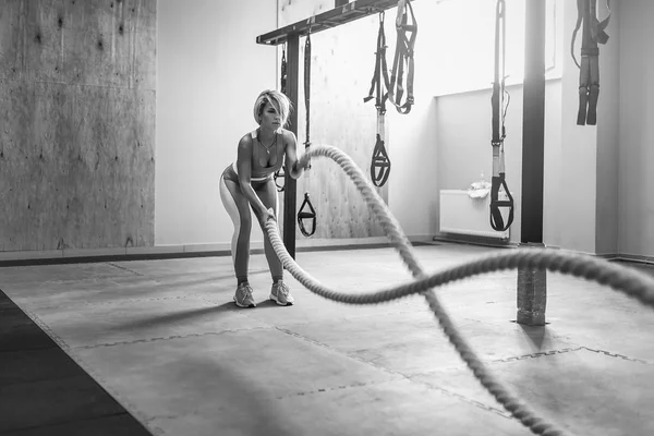 Kvinna med slaget rep övning i fitness gym. Unga kvinnliga bära sportkläder. — Stockfoto