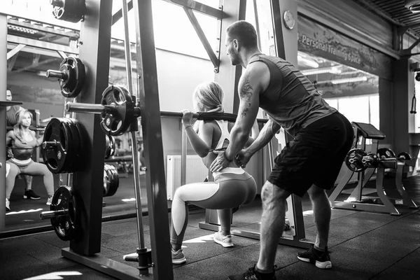 Sportif kız Yardımı salonunda kişisel onu antrenman ör ile bodur egzersizleri yapıyor.