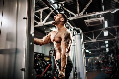 Yakışıklı kaslı Fitness vücut geliştirmeci Triceps için ağır egzersiz yaparak