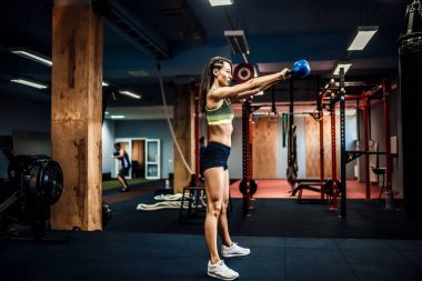 Bir su ısıtıcısı çan salıncak yapmak çekici kadın atlet.