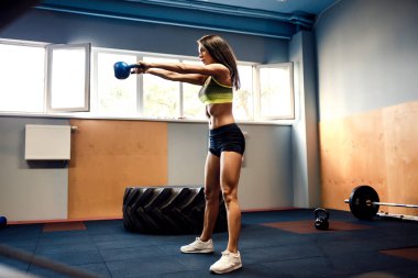 Bir su ısıtıcısı çan salıncak yapmak çekici kadın atlet