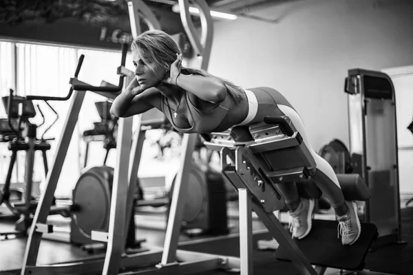 Sportos fiatal nő túlnyúlását az edzőteremben csinál. Nő, hajlításhoz, hát- és hasizmok — Stock Fotó
