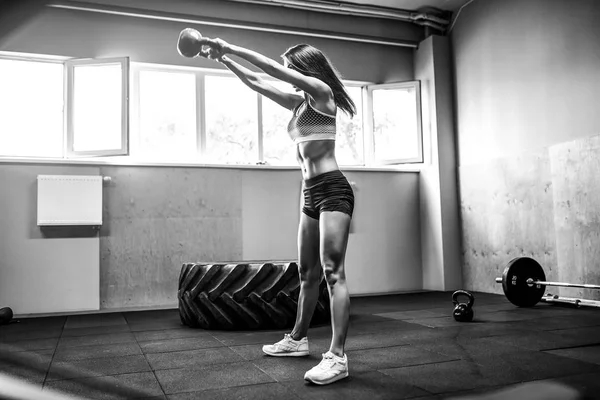 Atractiva atleta femenina realizando un columpio de campana de tetera —  Fotos de Stock