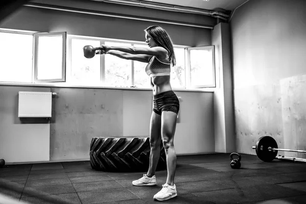 Athlète féminine attrayante effectuant une balançoire bouilloire-cloche — Photo