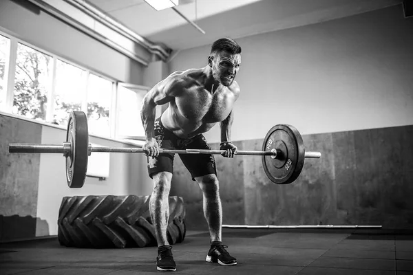 Genç adam bir halter kaldırma crossfit salonunda.