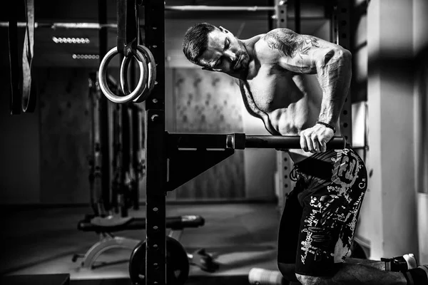 Starker muskulöser Mann macht Liegestütze auf unebenem Barren in Crossfit-Fitnessstudio — Stockfoto