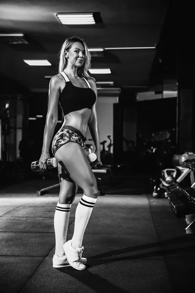 Fitness chica rubia posando y ejercitándose con la mancuerna — Foto de Stock