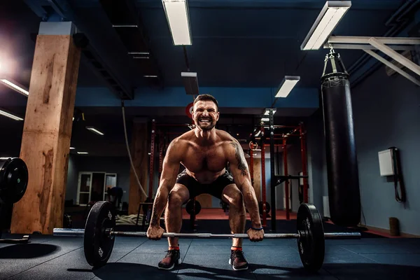 Homem fitness muscular fazendo deadlift um sino no moderno centro de fitness. Treinamento funcional . — Fotografia de Stock