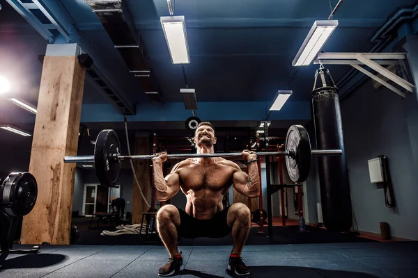 Muskulös fitness man gör marklyft en skivstång i modernt fitnesscenter. Funktionell träning. — Stockfoto