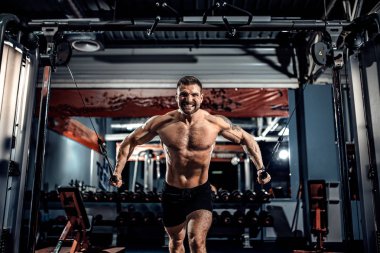 vücut geliştirmeci spor salonunda crossover kablo ile göğsüne üzerinde çalışıyor.