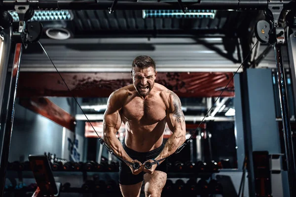 Culturista está trabajando en su pecho con cable cruzado en el gimnasio . — Foto de Stock