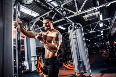 Yakışıklı kaslı Fitness vücut geliştirmeci Triceps için ağır egzersiz yaparak