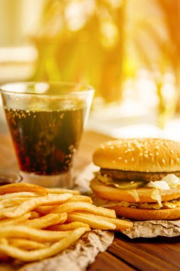 Burger patates kızartması ve kola ahşap arka plan üzerinde ile Kraft kağıt üzerinde