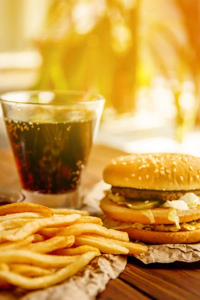 Burger patates kızartması ve kola ahşap arka plan üzerinde ile Kraft kağıt üzerinde