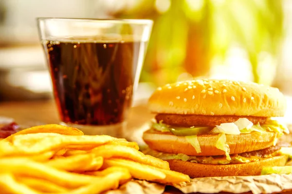 Burger patates kızartması ve kola ahşap arka plan üzerinde ile Kraft kağıt üzerinde