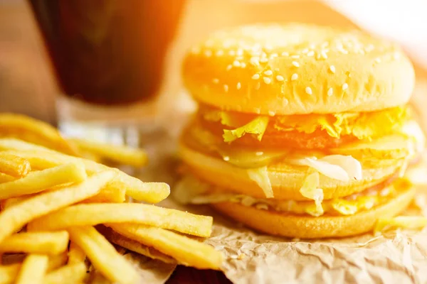 Burger patates kızartması ve kola ahşap arka plan üzerinde ile Kraft kağıt üzerinde