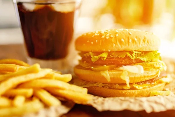 Burger patates kızartması ve kola ahşap arka plan üzerinde ile Kraft kağıt üzerinde