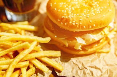 Burger patates kızartması ve kola ahşap arka plan üzerinde ile Kraft kağıt üzerinde