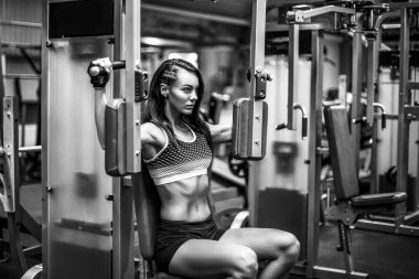 Genç ve sportif kadın göğüs kullanarak makine sinek
