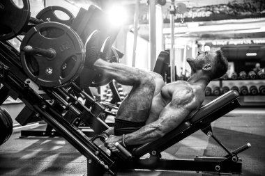 Bir Fitness kulübünde kullanan adam. Güçlü adam öğreniyor simülatörde bir egzersiz yapmak.