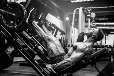 Bir Fitness kulübünde kullanan adam. Güçlü adam öğreniyor simülatörde bir egzersiz yapmak.