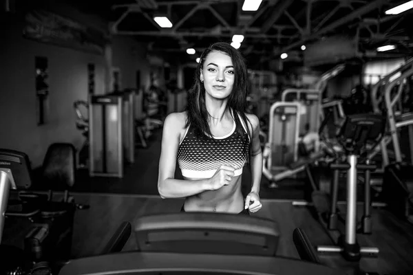 Молода фітнес-леді робить кардіо вправи в тренажерному залі, що працює на біговій доріжці . — стокове фото