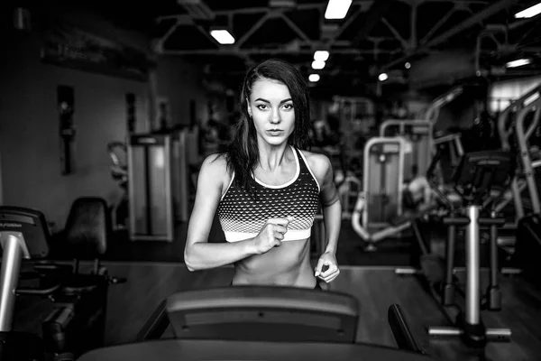 Fitness mladá žena, která dělá kardio cvičení v posilovně, běh na běžícím pásu. — Stock fotografie