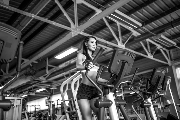 Joven mujer fitness haciendo ejercicios de cardio en el gimnasio corriendo en una cinta de correr . — Foto de Stock