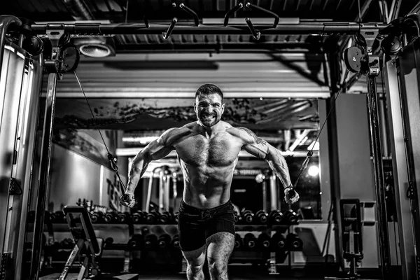 Culturista está trabajando en su pecho con cable cruzado en el gimnasio . — Foto de Stock