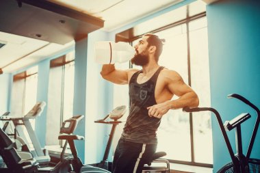 adam büyük şişe spor salonunda egzersiz basılı tutma veya içecek sudan sonra rahatlatıcı