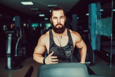 Kas koşu bandı üzerinde çalışan adam.