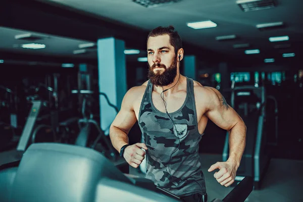 Kas koşu bandı üzerinde çalışan adam.