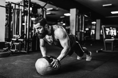 Çatı katı iç yerdeki egzersiz yaparken spor giyim ve iş tahta pozisyonu giyen kaslı genç adam