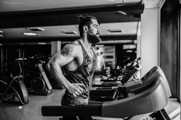 Kas koşu bandı üzerinde çalışan adam.