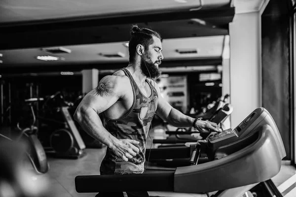 Kas koşu bandı üzerinde çalışan adam.