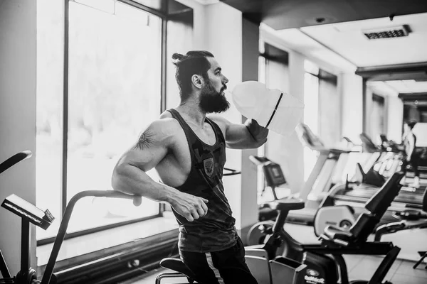 adam büyük şişe spor salonunda egzersiz basılı tutma veya içecek sudan sonra rahatlatıcı