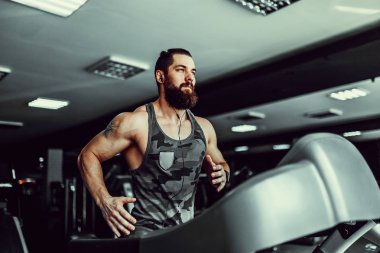 Kas koşu bandı üzerinde çalışan adam.